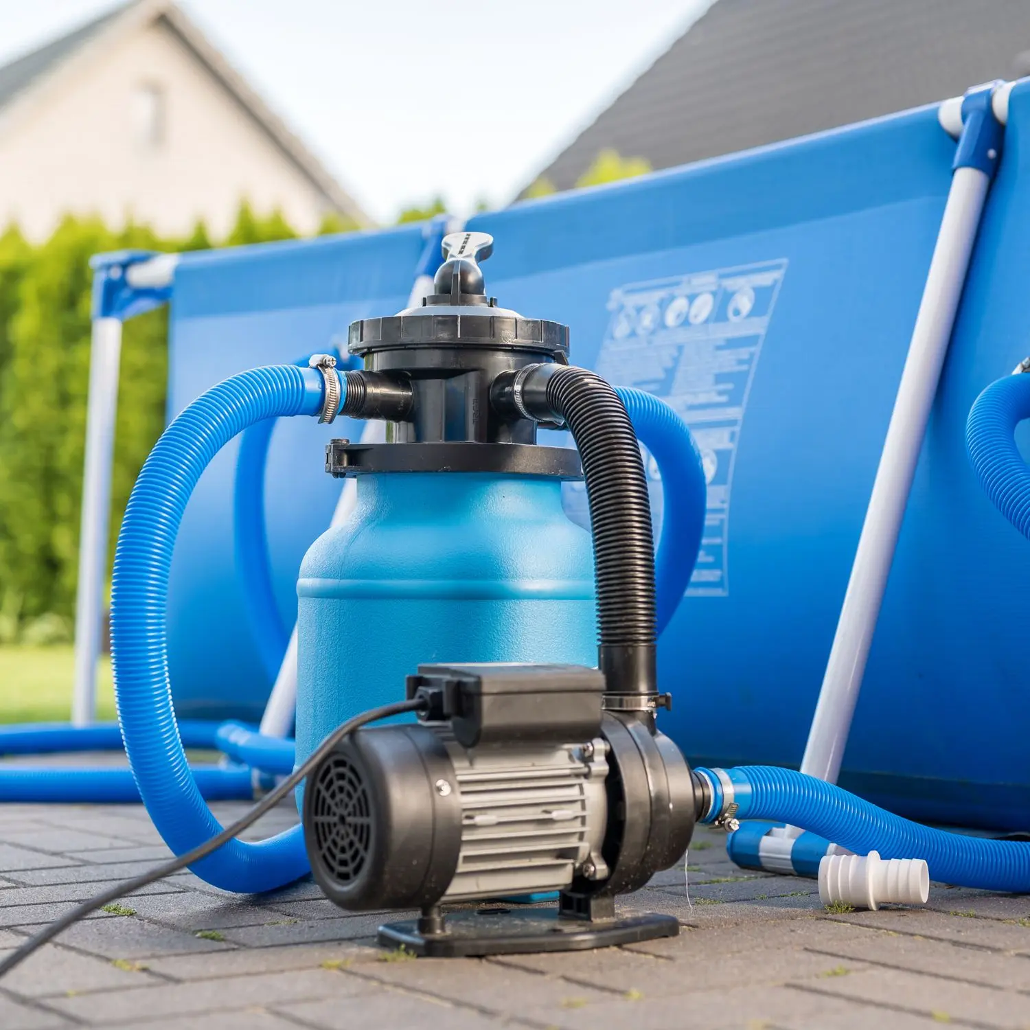 Pool-Filterpumpe in Blau mit einem Aufstellpool im Hintergrund
